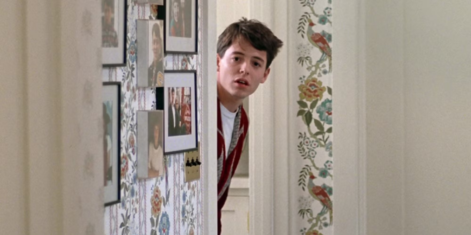 Ferris Bueller in his bathrobe peeking around a hallway door, the 'You're still here?' moment from Ferris Bueller's Day Off